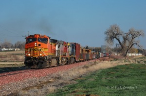 The DenGrf with a H2, a warbonnet Dash-8, and a CSX AC6000 nears the top of Loveland Hill north of Loveland.